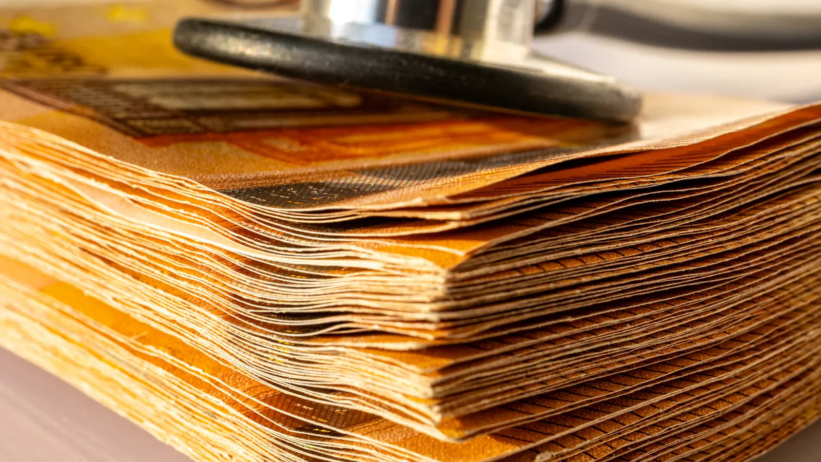 A stethoscope resting on a thick stack of papers