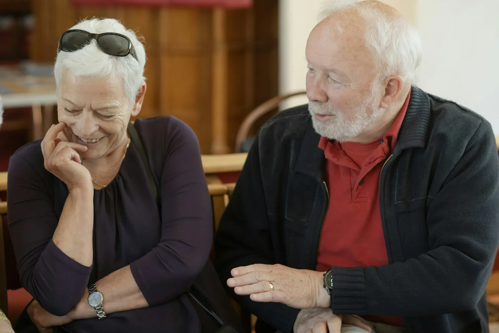 An older woman and man sitting side by side, smiling and talking