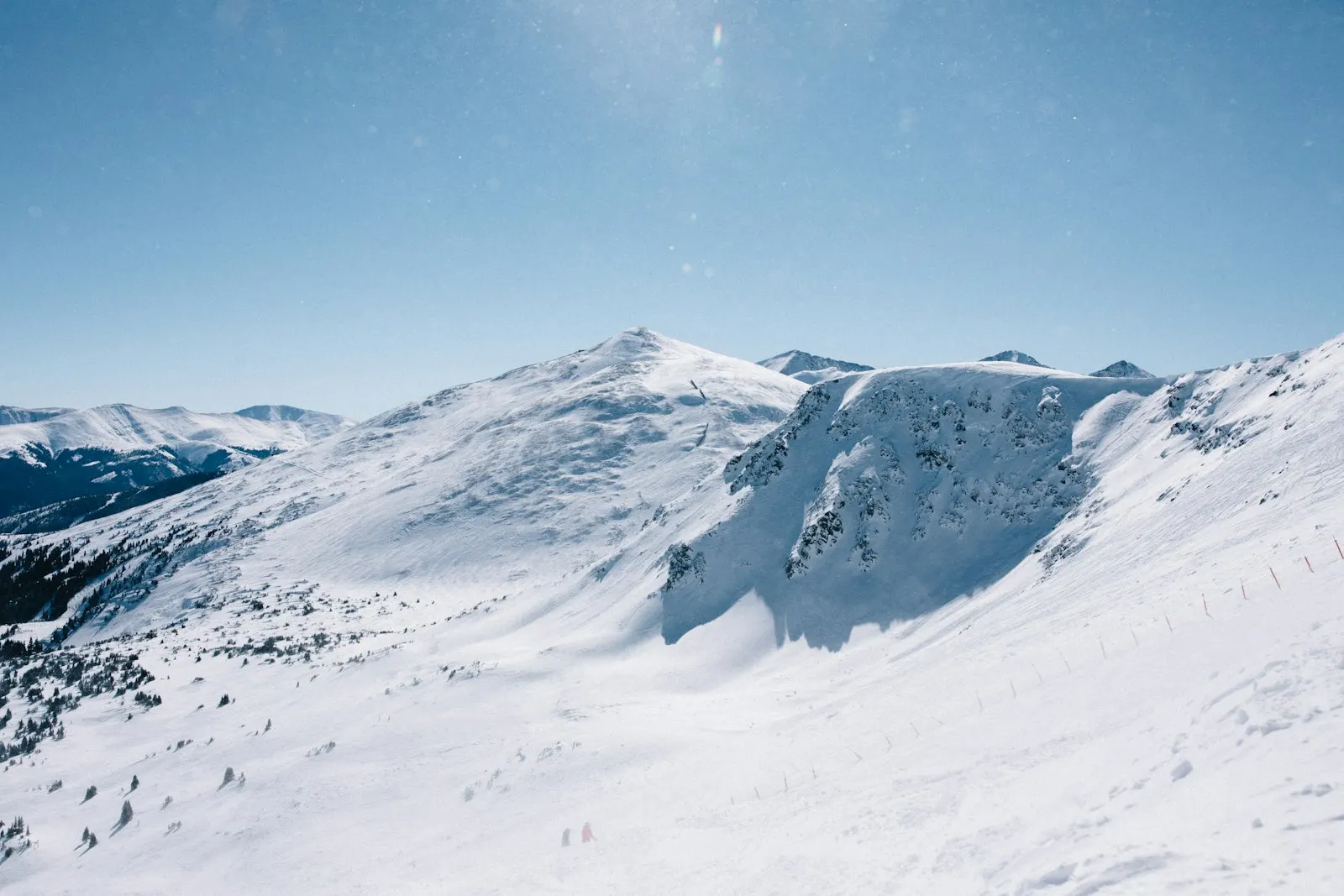 A skier crossing a snowy slope below a mountain peak near Breckenridge, Colorado