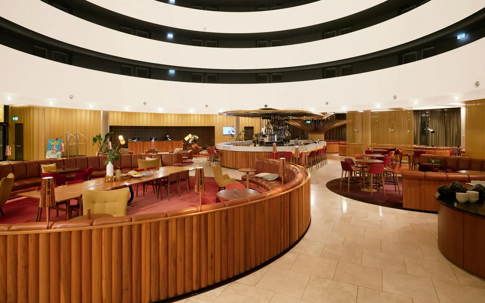 A modern hotel lobby with curved wooden walls and lounge seating
